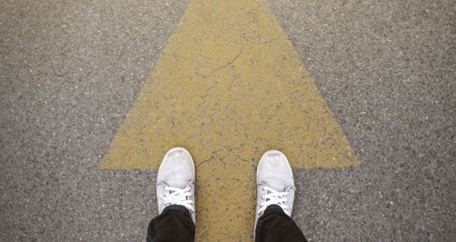 Gelber Pfeil auf Asphalt
