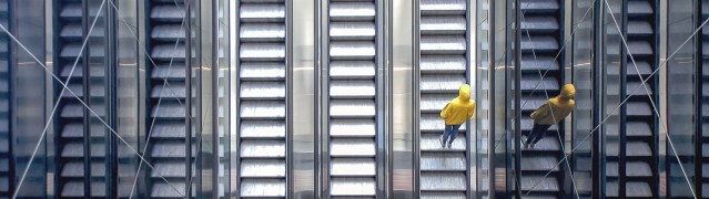 Veränderung der Unternehmenskultur dargestellt durch Mensch auf Rolltreppe
